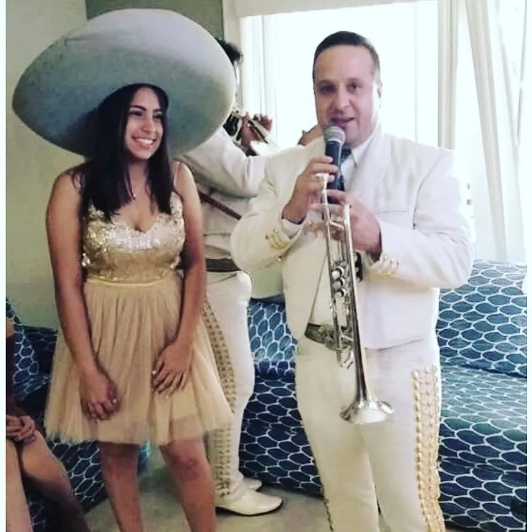 Quinceañera con sombrero de charro y el trompetista del mariachi